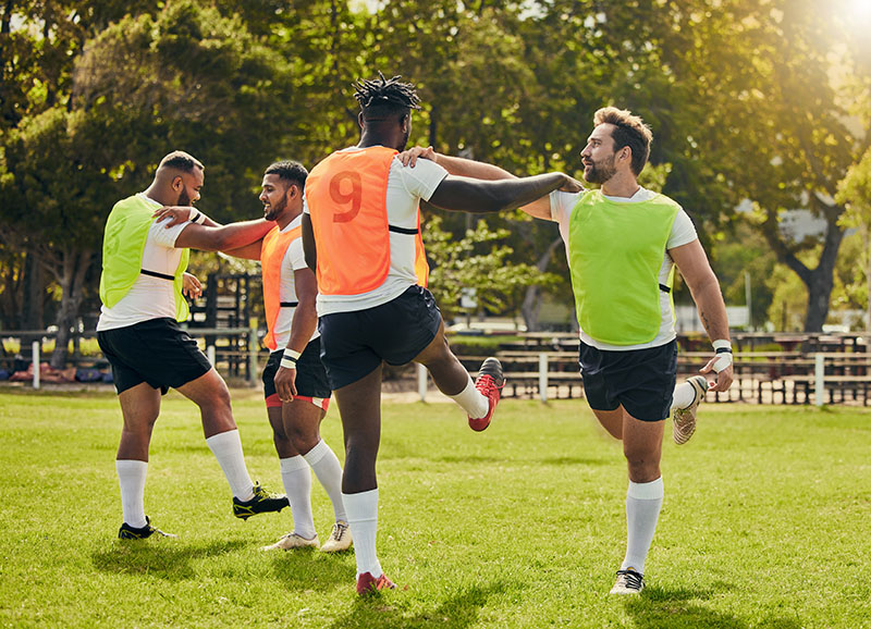 Players in their pre-match warm-up doing leg swings.